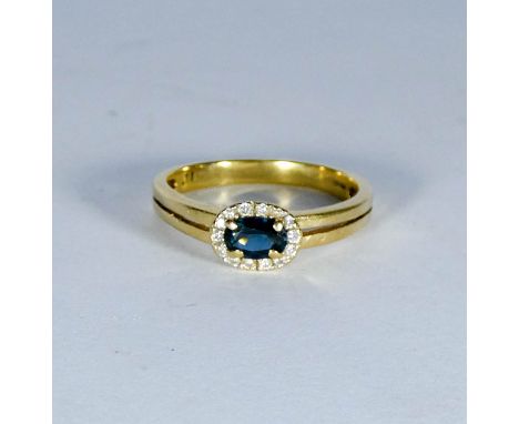 Oval sapphire and diamond cluster ring on 18ct yellow gold shank, ring size Q/R