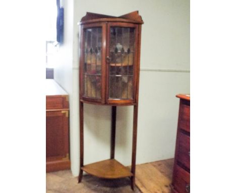 Edwardian inlaid mahogany bow front corner cabinet with under tier fitted with lead light doors and tray top 