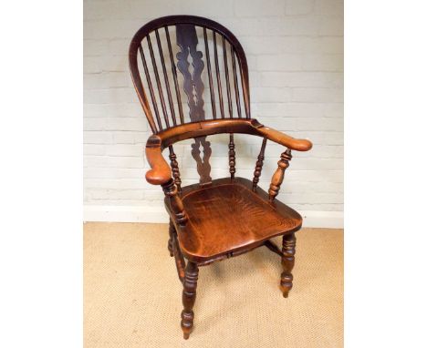 An elm tub shaped stick back Windsor elbow chair with turned spindles and legs   One spindle damaged 