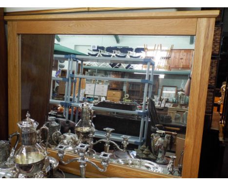 A large modern oval mantel style wall mirror in heavy light oak frame 