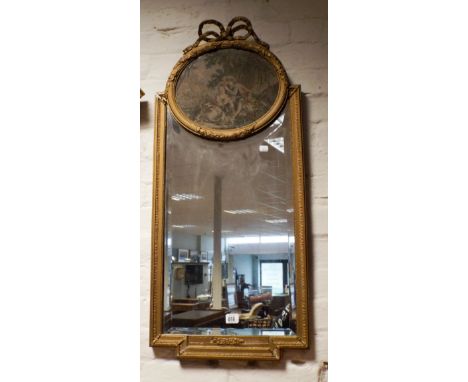 A Victorian gilt framed ribbon decorated wall mirror with tapestry panel in the top 
