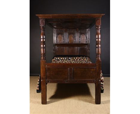 A 17th Century & Later Oak Full Tester Bed. The paneled tester with moulded edge raised on an arcaded head board and turned f