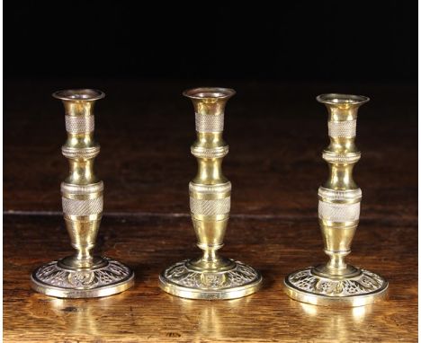 A Set of Three Delightful 18th Century French Seamed Brass Taper Sticks. The decorative engine turned stems above floral deco