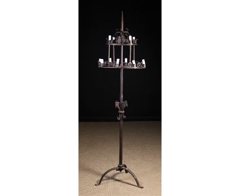 A Wrought Iron Floor Standing Candelabra: The tall central stem having a spike top and tripod base supporting a two tiered fr