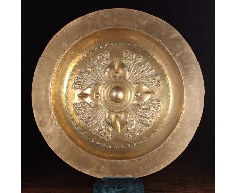 A Large 16th Century Nuremberg Brass Alms Dish. The centre panel ornamented with four lappets between foliate sprays issuing 