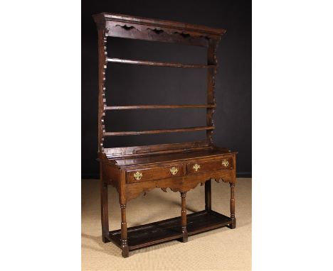 An 18th Century Welsh Joined Oak Dresser with Rack. The rack having a moulded top above a serpentine rail and three open shel