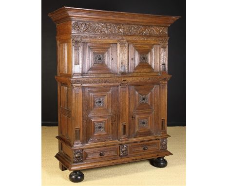 A Mid 17th Century Flemish Carved Oak Four-door Cupboard or ‘Beeldenkast’ with an upper and lower cupboard above two frieze d