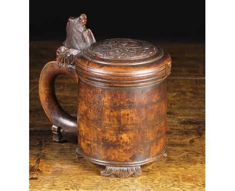 An 18th Century Norwegian Birchwood Peg Tankard. The domed lid carved with a swirl of foliage and having an animal bust surmo