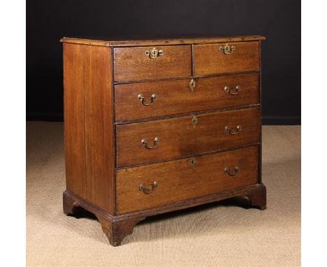 A Georgian Oak Chest of Drawers. The two short over three long drawers divided by reeded moulding and standing on bracket fee