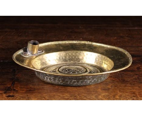 A 17th Century Flemish Brass Alms Dish with a candle socket riveted to one side of the border. The centre panel adorned with 
