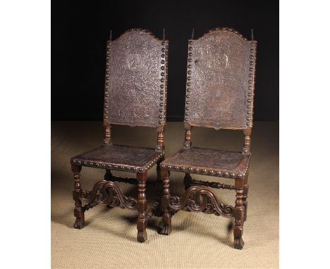 A Pair of Late 17th/Early 18th Century Portuguese Tooled Leather Chairs (A/F). The tall hump-topped backs & seats embellished