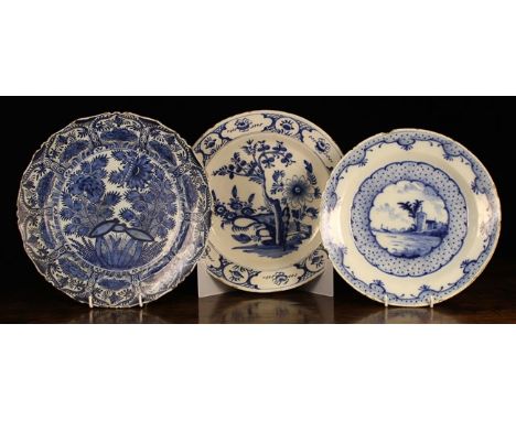 Three Large 18th Century Blue & White Delft Plates: The largest decorated with a fruit tree and flowers to the centre panel, 