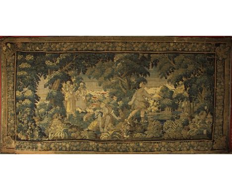 A 17th Century Verdure Tapestry (A/F) depicting a woodland scene with a couple onlooked by a small gathering of two eastern f