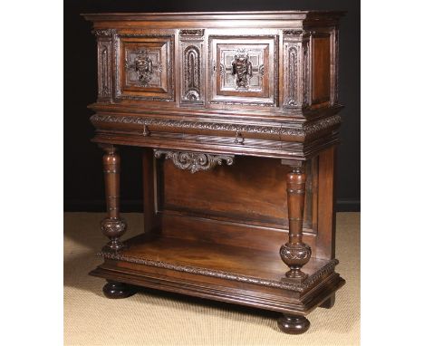 A 17th Century Style Carved Walnut Buffet. The cupboard having two moulded panel doors centred by relief carved satyrs' heads
