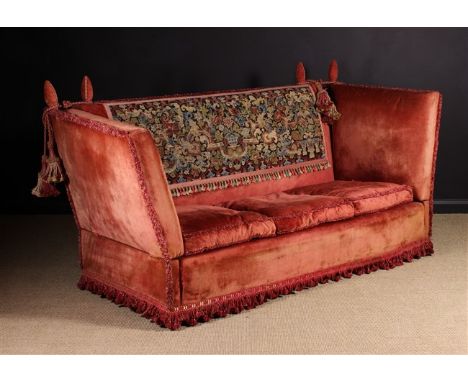 A Fine Knowle Settee. The upholstered back, hinged sides, sprung seat and three swab cushions covered in faded crimson velvet