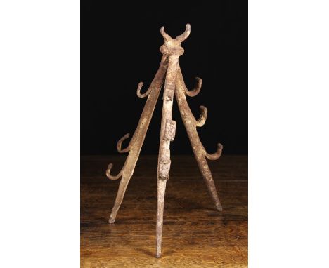 A Medieval Spanish Wrought Iron Triangular Fire Dog. The splayed tripod with three spit hooks to each support, 14½ ins (37 cm