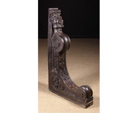 A Large 17th Century Style Carved Oak Architectural Bracket, boldly carved with a grimacing face and strapwork, with Tudor ro