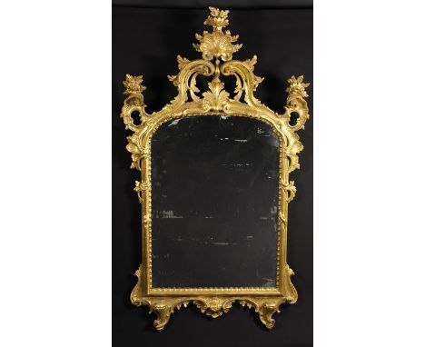 A Pretty 18th Century Carved Giltwood Mirror. The arched mirror plate in a moulded surround with beaded edge surmounted by an