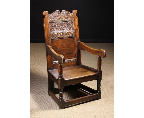 A 17th Century Oak Wainscot Chair attributed to Herefordshire.  The shaped cresting rail gouge carved with interlinked C-scro