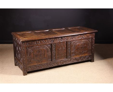 A Fine 17th Century Oak Marriage Coffer. The lid composed of four moulded panels on iron staple hinges above a triple panelle