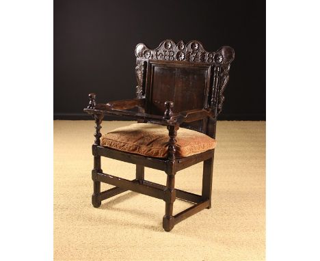 An Unusual Joined Oak Armchair with pegged bar tray to the front. The broad shaped cresting rail carved with initials HB and 