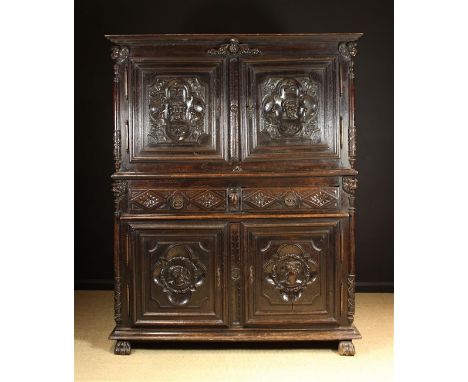 A Large 18th Century French Carved Oak Armoire Corps Deux. The upper & lower cupboards having moulded panel doors boldly carv