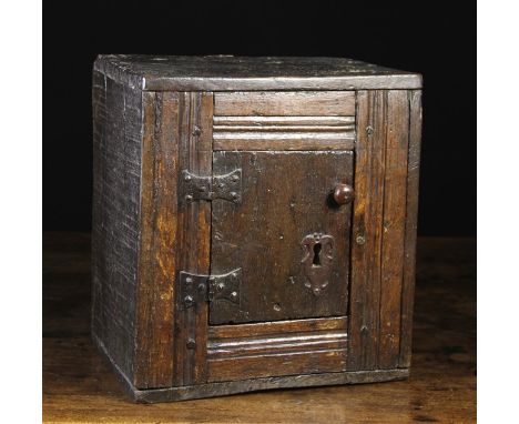 A Small Late 17th Century Joined Oak Cupboard. The central door on iron hinges with an iron escutcheon and small turned woode