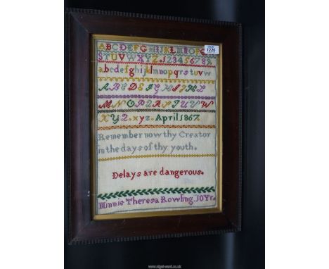 A framed and glazed brightly coloured wool sampler by Minnie Theresa Rowling, 10 years, April 1867: an alphabet and verse sam