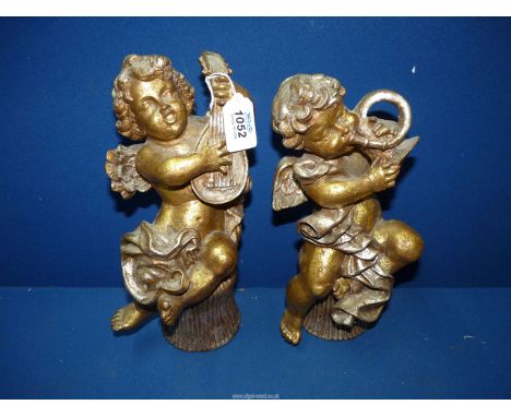 An interesting pair of silver and gilt effect carved Putti playing musical instruments sitting on reeded seats, 11" tall.