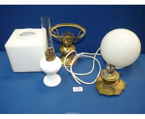 Two white glass hanging light shades, a ceramic lamp and two brass lamp bases (one being a ship's oil lamp).