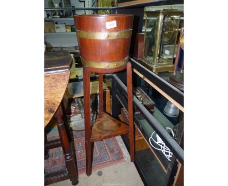 A 20th century coopered brass bound planter on tripod base with shelf, 36" tall.