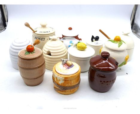 Eleven ceramic Honey pots.