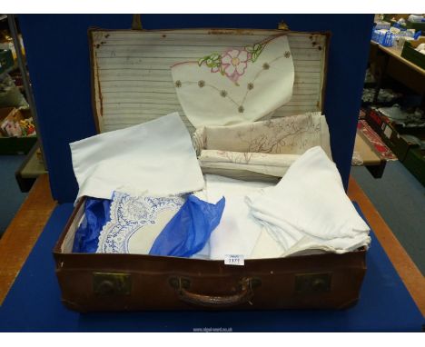 A vintage suitcase full of vintage linen and lace, damask, embroidered etc.