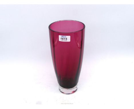 A heavy Dartington crystal glass vase in ruby red with inner vertical ribs and thick clear base, 11" tall x 5" wide.