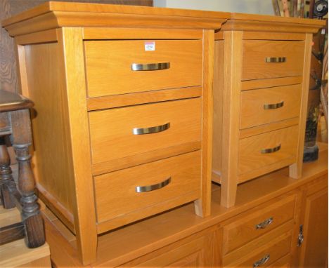 A pair of contemporary light oak three drawer bedside chests, w.54cm