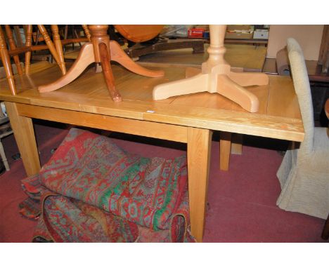 A contemporary light oak extending dining table, having two extra drop-in leaves, max. length 203cm