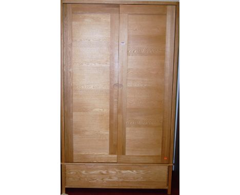 A good contemporary light oak double door wardrobe, having single long lower drawer, w.115cm