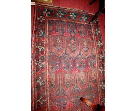 A Persian woollen rug, having an architectural field and trailing tramline borders, 248 x 120cm (worn)