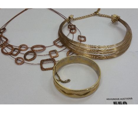 A Gold Coloured Bangle Along With Two Necklaces.
