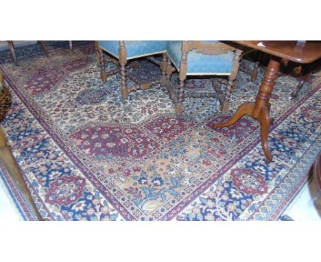 A Large 20th Century Eastern Carpet with multi borders on red and green ground.