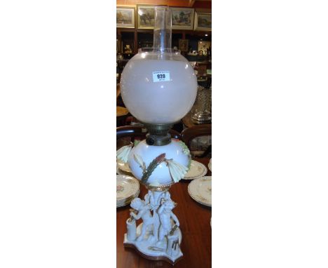 A Moore Bros. White Glazed Porcelain Oil Lamp, accentuated with gilding, the body applied with flowering cacti and supported 