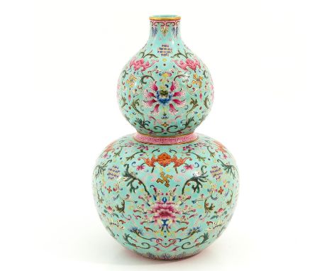 Light blue ground with decor of flowers, bats, and Chinese symbols, Qianlong mark, 27 cm. tall. 