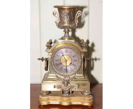 Ornate brass mantel clock with urn top and stand, 46cm high.