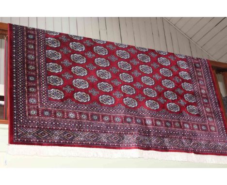 Bokhara carpet with a red ground 3.00 by 2.00.
