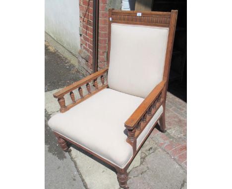 Late 19th / early 20th Century oak low seat library gentleman's armchair with carved and spindle decoration on turned taperin