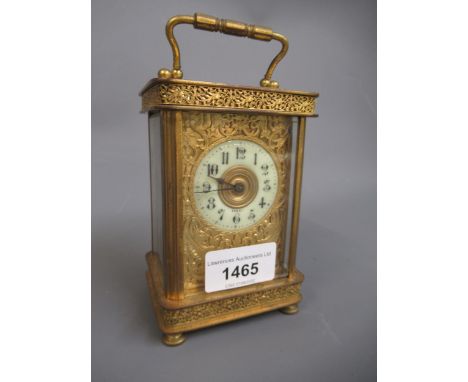 Small brass cased carriage clock, the ornate fretwork case and gilt dial surrounding an enamel chapter ring with Arabic numer