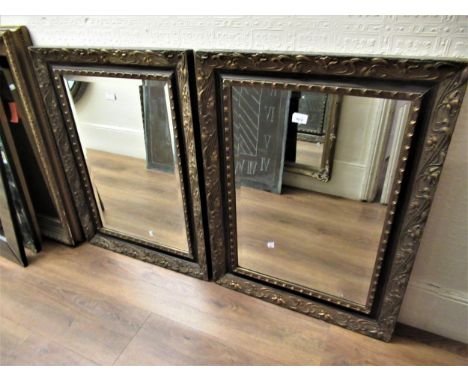 Pair of Art Nouveau gilt composition rectangular wall mirrors, the frames decorated in relief with stylised flowers enclosing