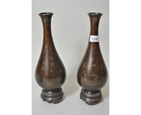 Pair of Chinese bronze baluster form vases inlaid with silver / copper, with integral circular bases, inlaid with various flo