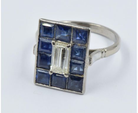 Platinum dress ring set central baguette cut diamond flanked by ten square sapphires, the diamond approximately 8mm x 4mm 