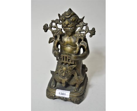 Tibetan dark patinated bronze in the form of a stylised figure riding an animal, on an integral rectangular base, 9.5ins high